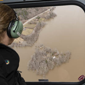 The Governor General is looking at flooded areas from a helicopter. 