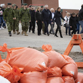 La gouverneure générale marche aux côtés d'un groupe de membres des Forces armées canadiennes. 
