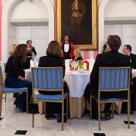 Photo of the head table and the Governor General delivering remarks from a podium at the State dinner. 