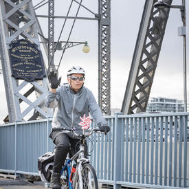 Un cycliste sur le pont Alexandria salue.