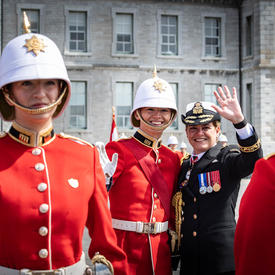 The Governor General and a member of RMC wave to the public. 