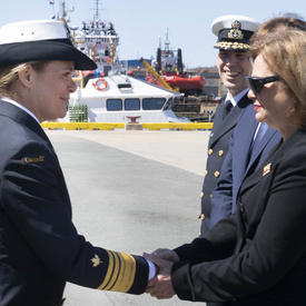 La gouverneure générale Julie Payette serre la main de Son Honneur l'honorable Judy May Foote, lieutenante-gouverneure de Terre-Neuve-et-Labrador, par une journée ensoleillée dans un port.