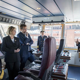 A group of 4 people including Governor General Julie Payette is listening to a Canadian Coast Guard official, inside the cockpit of the ship Captain Molly Kool.