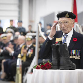 Veteran salutes a pair of boots. 