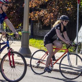 The Governor General cycles next to a Navy Bike Ride participant 