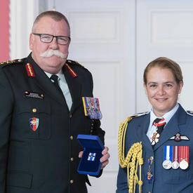 Le brigadier-général Anderson accepte sa médaille de la gouverneure générale et pose pour une photo.
