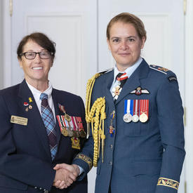 Debra Reid accepte sa médaille et pose pour une photo avec la gouverneure générale.