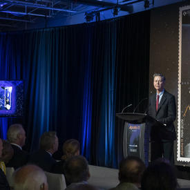 Mr. Ettinger delivers remarks at a podium. 