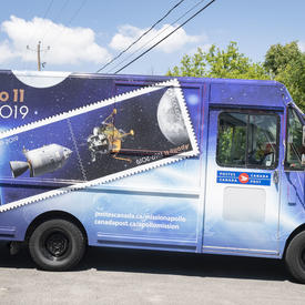 Photo d'un camion de Postes Canada peint avec le dessin Apollo 11.