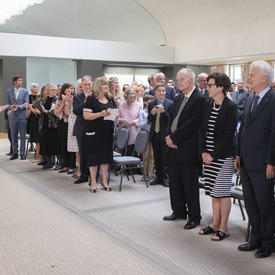 The Governor General and guests in attendance applaud the Order of Canada members as they take their seats.