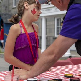 A child getting her face painted.