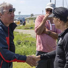 The Governor General meets and shakes hands with a local resident at Île d’Entrée.