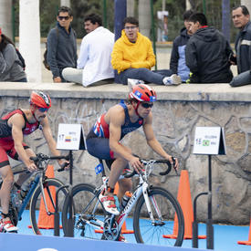 Men’s triathletes entered the transition section on their bikes. 