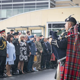 The Governor General, the Chief of the Defence Staff and guests in attendance stand and salute during the ceremony.