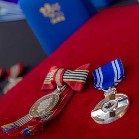 A photo of a Sovereign's Medal for Volunteers and a Meritorious Service Medal.