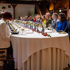 La gouverneure générale est assise parmi les invités à une longue table lors d'un dîner offert par le premier ministre Rutte.