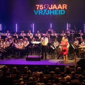 The Governor General delivers a speech at the commemorative ceremony in Terneuzen, orchestra behind. 