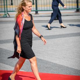 The Governor General walks along a red carpet towards her seat at the commemorative ceremony.