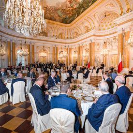 A photo of the Heads of State sitting at tables inside the Royal Castle in Warsaw.