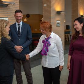The Governor General shakes hands with an employee of the Organization for the Prohibition of Chemical Weapons, while others look on.