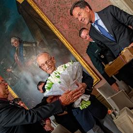 The Prime Minister of the Netherlands hands tulips and a box of bulbs to Canadian veteran Don White.