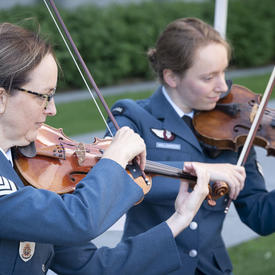Des musiciens des Forces armées canadiennes jouent au cours d'une cérémonie extérieure de l'Ordre du Canada.