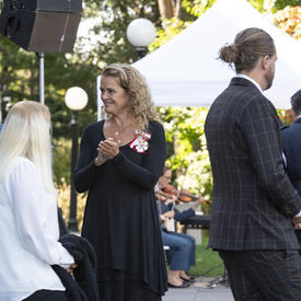 The Governor General applauds as the recipients of the Mixed Honours ceremony walk toward their seats.