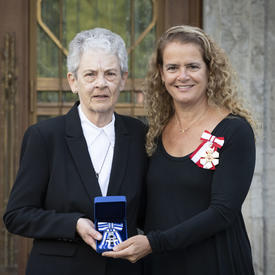 The Governor General takes a photo with a recipient of the Meritorious Service Cross.