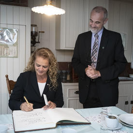 The Governor General signing the guest book at the Maison Alphonse-Desjardins.