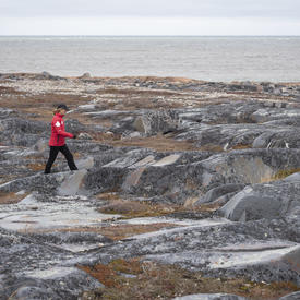 The Governor General is walking over rocky terrain.