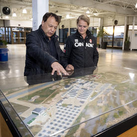 The Governor General and the mayor looking at a plan of Churchill. 