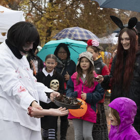 Kids look on as a Rideau Hall staff member holds a Halloween inspired dish.