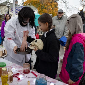 Kids look on as Rideau Hall staff show off ghoulish treats.