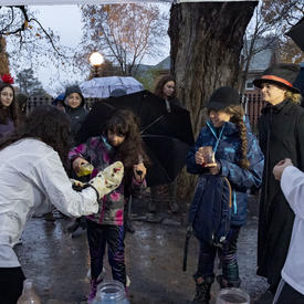 Kids look on as a staff member shows off ghoulish delights.