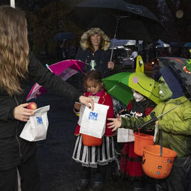Children receiving Halloween treat bags.