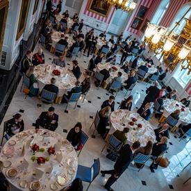 A photo from above of guests seated inside the Tent Room of Rideau Hall during the Luncheon for the National Silver Cross Mother.
