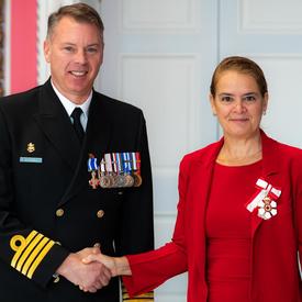 The Governor General shakes hands with Commander Bonnar. 