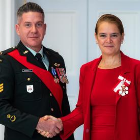 The Governor General shakes hands with Sergeant Barrett. 