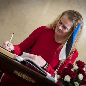 The Governor General signs the presidential guest book.
