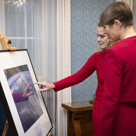 President Kersti Kaljulaid and the Governor General are looking at photo.. 
