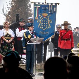 Governor General Julie Payette, wearing the Royal Canadian Air Force uniform, is delivering a speech at a podium at Pontecorvo Monument..