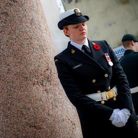 A female member of the Canadian Armed Forces is standing sentry at one corner of the Pontecorvo Monument.