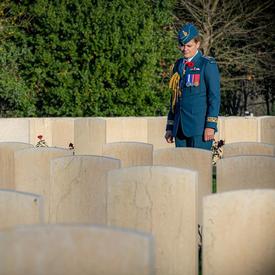 Governor General Julie Payette, wearing the Royal Canadian Air Force uniform, is seen from a distance, visiting the Cassino War Cemetery.