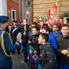 La gouverneure générale salue un groupe d'enfants ayant des drapeaux canadiens et italiens à la main. 