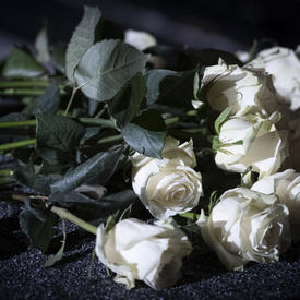 Des roses blanches posées sur une table lors de la cérémonie commémorative de la Polytechnique.