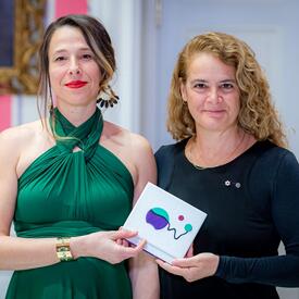 Anne-Marie Desmeules se tient aux côtés de la gouverneure générale. 