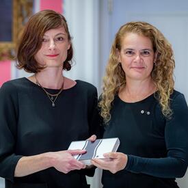 Céline Huyghebaert se tient aux côtés de la gouverneure générale. 