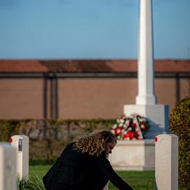 The Governor General lays flowers on a tomb. 