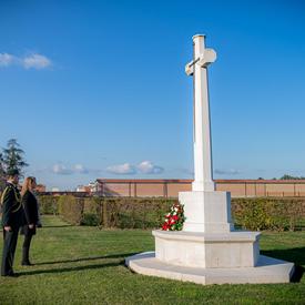 The Governor General stands in front of a monument at the Villanova Canadian War Cemetery.