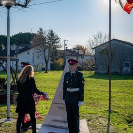The Governor General lays a scarf on a monument at the Villanova Canadian War Cemetery.